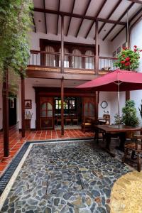 un patio al aire libre con mesa y sombrilla en Casa Lola Hotel Boutique en Salamina