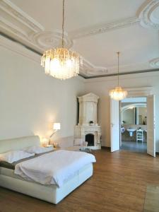 a bedroom with a bed and chandeliers and a fireplace at Luxury Design City centre Apartment in Brno