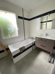 a white bathroom with a tub and a sink at Villa Garance Ile et Villas Groix in Groix