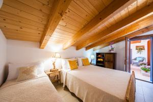 Dos camas en una habitación con techos de madera. en La Casa di Mannazzotta 2, en Castelsardo