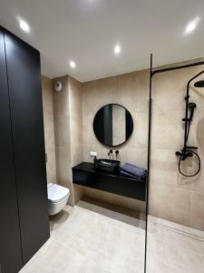 a bathroom with a toilet and a sink and a mirror at Osiedle Legionów Apartament in Kielce
