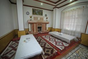 a living room with two tables and a fireplace at Rustambey House in Khiva