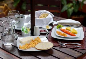 een houten tafel met borden eten erop bij Casa Lola Hotel Boutique in Salamina