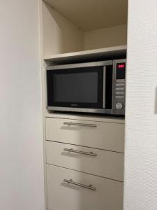 Un four micro-ondes est installé au-dessus d'une commode. dans l'établissement Appartement City Enschede (free private parking), à Enschede