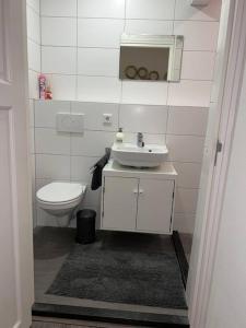La salle de bains blanche est pourvue de toilettes et d'un lavabo. dans l'établissement Appartement City Enschede (free private parking), à Enschede
