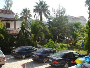 tres coches estacionados en un estacionamiento con palmeras en Marylin, en Sidari