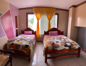 a bedroom with two beds and a window at Hotel Los Bancos in San Miguel de los Bancos