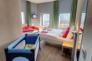 a small room with a bed and a couch at MEININGER Hotel Amsterdam City West in Amsterdam