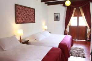 Salamina的住宿－Casa Lola Hotel Boutique，酒店客房设有两张床和窗户。