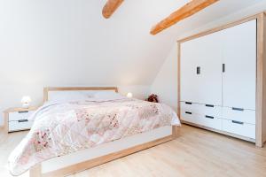 a white bedroom with a bed and a large mirror at Lehmberg Über den Feldern in Rathlau