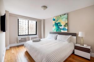 ニューヨークにあるLUXURY 4 BEDS 1.5 BATHS BY CENTRAL PARKの白いベッドルーム(大型ベッド1台、窓付)