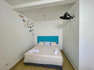 1 dormitorio con 1 cama con cabecero azul en Hostal Inn 2, en Flores