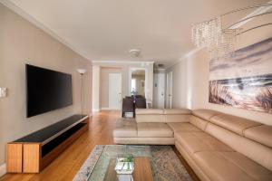 ein Wohnzimmer mit einem Sofa und einem Flachbild-TV in der Unterkunft LUXURY 4 BEDS 1.5 BATHS BY CENTRAL PARK in New York