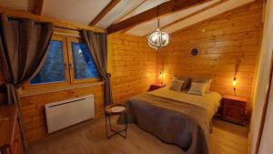 a bedroom with a bed in a wooden cabin at Chalet « à l’orée du bois » in Liézey