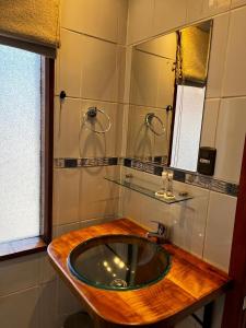 ein Badezimmer mit einem hölzernen Waschbecken und einem Spiegel in der Unterkunft Hotel y Cabañas Villarrica in Villarrica