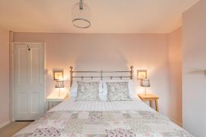 a bedroom with a large bed with two lamps at Bunny Cottage by Bloom Stays in Hythe