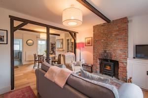 a living room with a couch and a brick fireplace at Bunny Cottage by Bloom Stays in Hythe