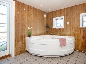 a bath tub in a bathroom with wooden walls at 9 person holiday home in Harbo re in Harboør