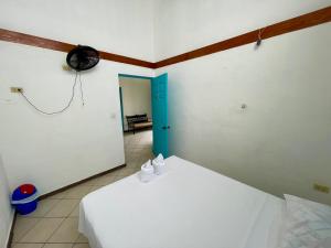 um quarto com uma cama e um relógio na parede em Hostal Inn 2 em Flores