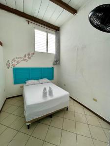 Hostal Inn 2 في فلوريس: غرفة نوم عليها سرير وحذيين