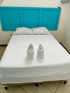 Una cama con dos zapatos encima. en Hostal Inn 2, en Flores