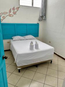 ein Bett in einem Zimmer mit zwei Schuhen darauf in der Unterkunft Hostal Inn 2 in Flores