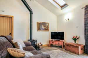 a living room with a fireplace and a tv at No 3 The Dairy in Llangefni