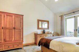 a bedroom with a bed and a dresser and a mirror at No 3 The Dairy in Llangefni