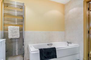 a bathroom with a white tub and a shower at No 3 The Dairy in Llangefni +13 photos