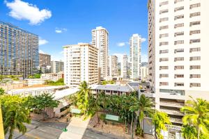 um horizonte da cidade com edifícios altos e palmeiras em Cozy Apt in Pacific Monarch - 1 Block to Beach! em Honolulu