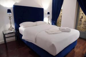 Palacio Julio Hotel في بوبلا: غرفة نوم بسرير كبير عليها شراشف ووسائد بيضاء