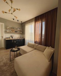 uma sala de estar com um sofá e uma mesa em Square INN Modern Studio City Center em Tirana