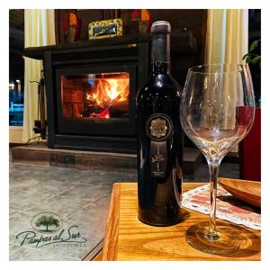 a bottle of wine and a wine glass on a table at Pampas al Sur in Colorado River +17 photos