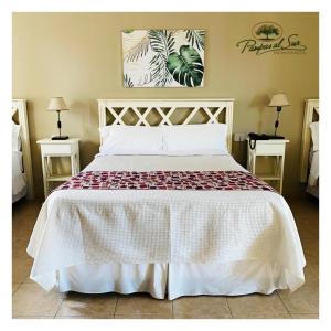 a bedroom with a large white bed with two tables at Pampas al Sur in Río Colorado