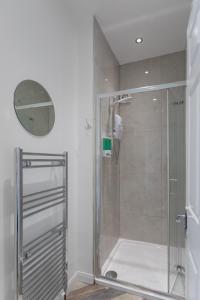 een douche met een glazen deur in de badkamer bij The Avenue Belfast in Belfast