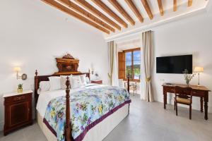Schlafzimmer mit einem Bett und einem Flachbild-TV in der Unterkunft Finca Sa Bastida Luxury Retreat & Spa Adults Only in Sant Joan