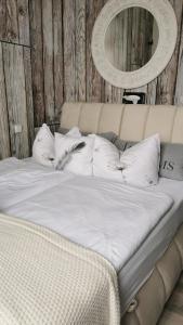 1 cama con sábanas blancas y almohadas en una habitación en Pension Zur Alten Post, en Havelberg