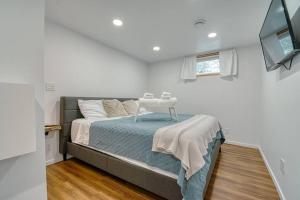 1 dormitorio con 1 cama y TV en la pared en The Ox + Bow, en Portage La Prairie