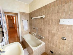 un baño con bañera y lavabo en CasaBella in Moltrasio – Lake Como, en Moltrasio 7 fotos más