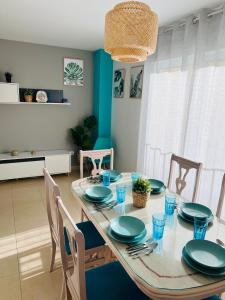 佩尼斯科拉APARTAMENTO SITUADO EN EL CENTRO CON 3 HABITACIONES, DISPONE DE AIRE ACONDICIONADO Y WIFI A 150m DE LA PLAYA Y EL CASTILLO的一间用餐室,配有一张带蓝色盘子和椅子的桌子