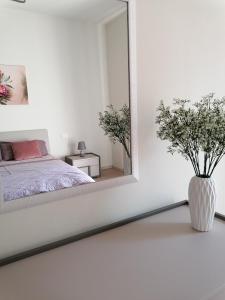 una camera bianca con specchio e letto di V & G House a Verona