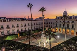 a large white building with palm trees in front of it at Kings House in Almería