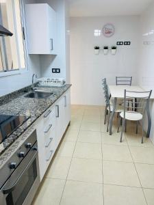 佩尼斯科拉APARTAMENTO SITUADO EN EL CENTRO CON 3 HABITACIONES, DISPONE DE AIRE ACONDICIONADO Y WIFI A 150m DE LA PLAYA Y EL CASTILLO的带水槽和桌椅的厨房