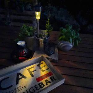 a sign on a table with plants and a lamp at Splendid in Vlašići