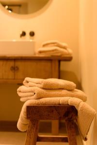 een stapel handdoeken op een kruk in een badkamer bij 't Knus Gewilg in Avelgem