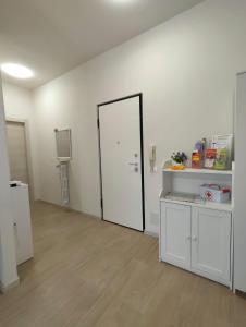 a large white room with a door and a kitchen at V & G House in Verona