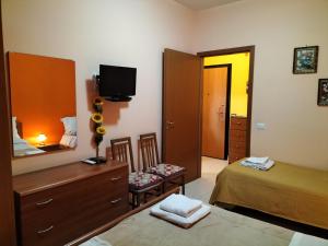 a bedroom with a bed and a dresser and a mirror at Da Rosa in Letojanni