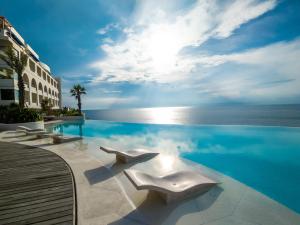 a swimming pool with a view of the ocean at Royal Avila Boutique Resort in Senggigi 