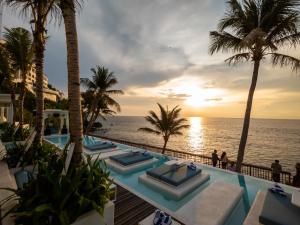 un complejo con una piscina infinita con palmeras y el océano en Royal Avila Boutique Resort, en Senggigi 