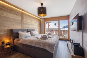 a bedroom with a large bed and a large window at Once Upon A Time in Leukerbad